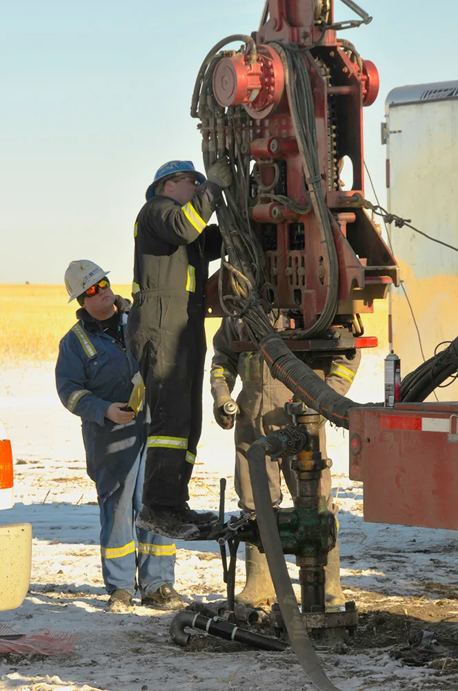 Field crew working beside wireline equipment at a wellsite
